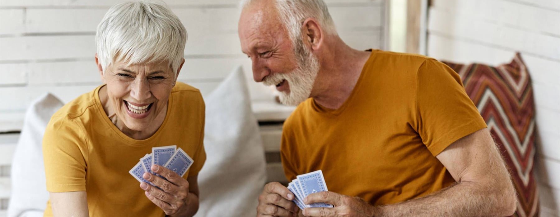 a man and woman sitting at a table playing cards