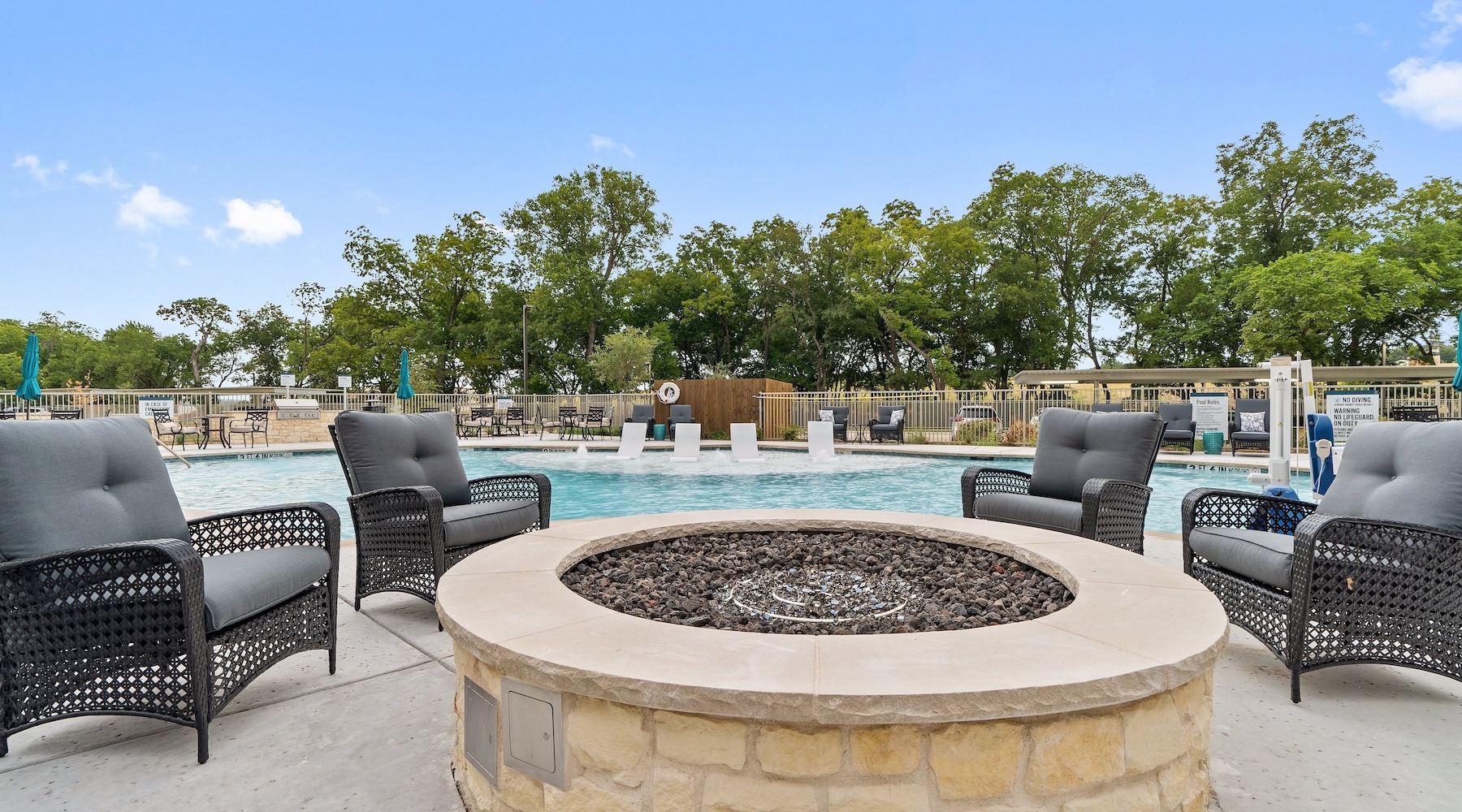 a firepit with chairs next to a pool