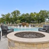 a firepit with chairs next to a pool