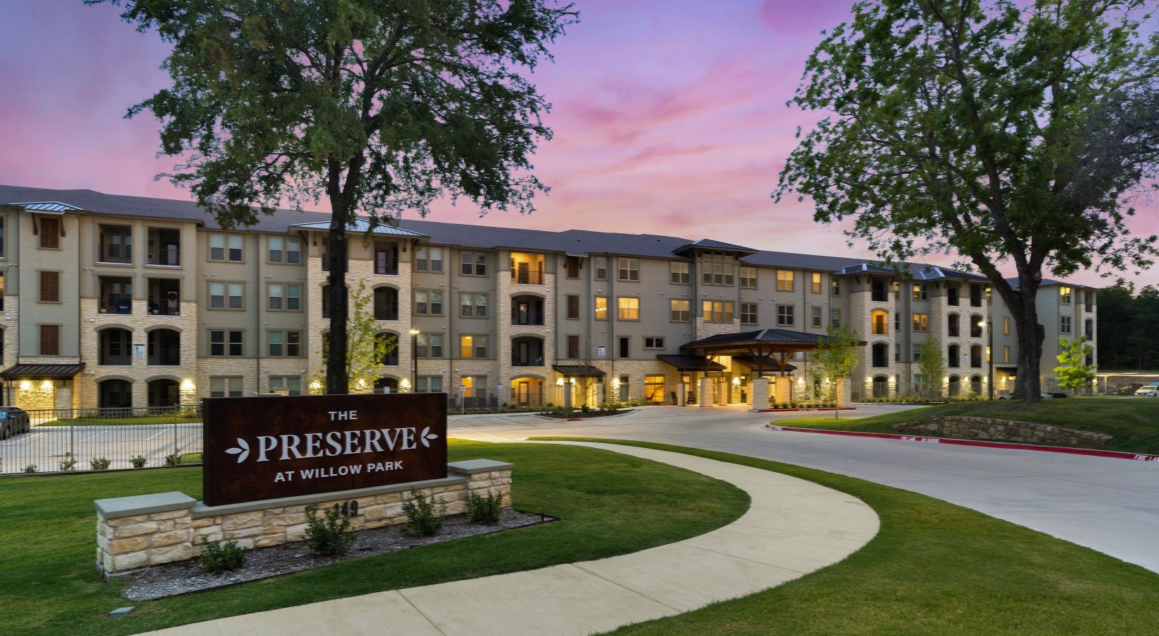 The essence of exceptional living a building with a sign in front that reads the preserve at willow park