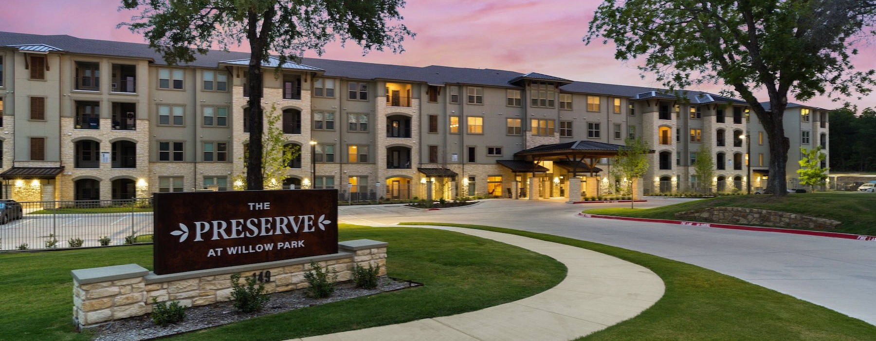 a building with a sign in front that reads the preserve at willow park