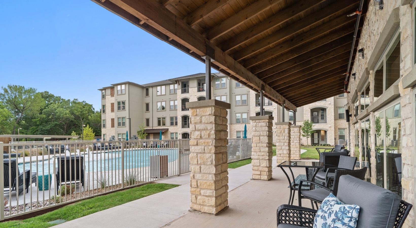 Find your perfect fit at Preserve at Willow Park a patio with chairs and tables and a fence with a pool in the background