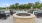 a group of chairs around a firepit in front of a pool