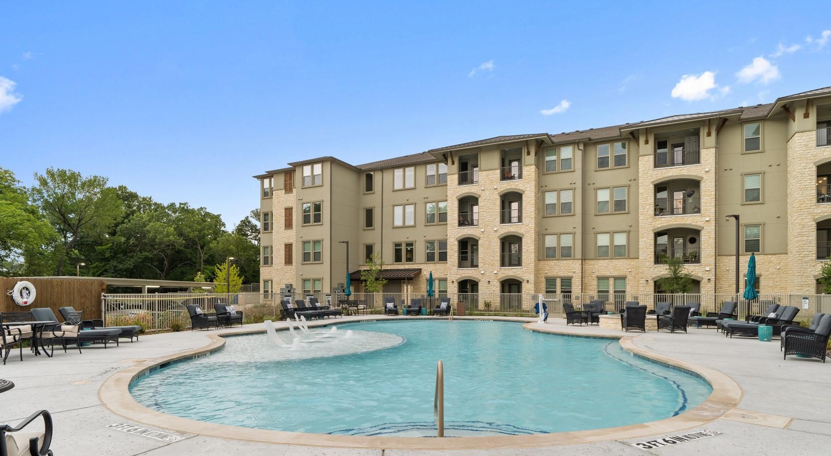 Resort-style swimming pool a large building with a pool in front of it
