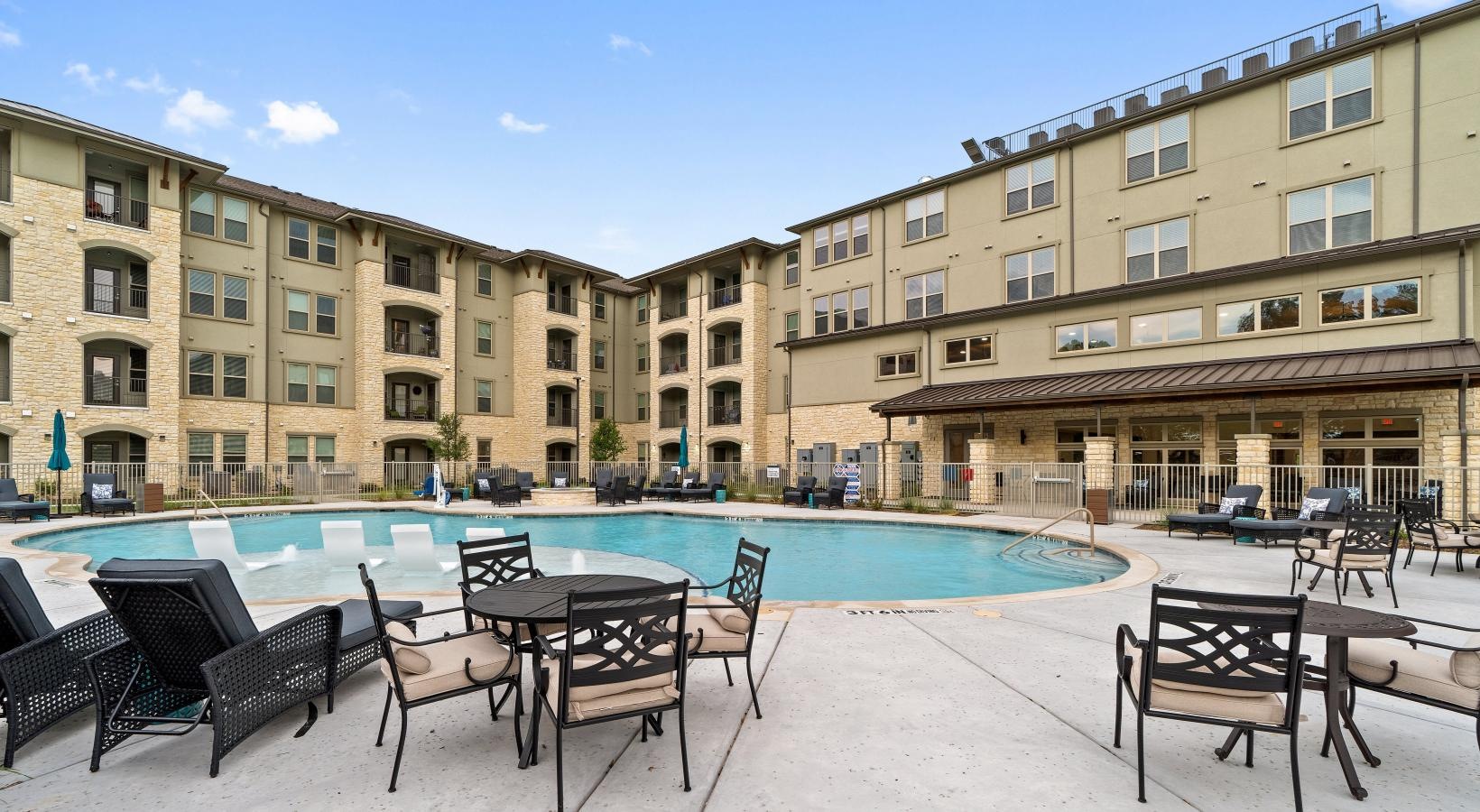 The essence of exceptional living a pool with chairs and tables by it and buildings in the background